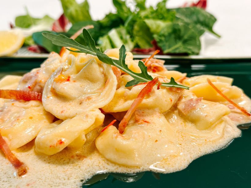 Ravioli cu carne, sos de smântană cu bacon, ceapă coaptă, pătrunjel, mentă, ardei roșu
