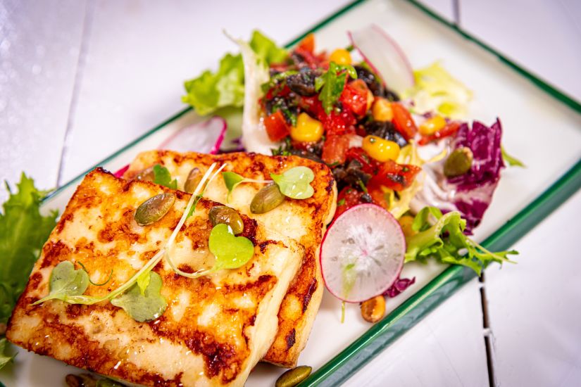 Halloumi cu mix de semințe, salsa de roșii, măsline, porumb și mix de salată